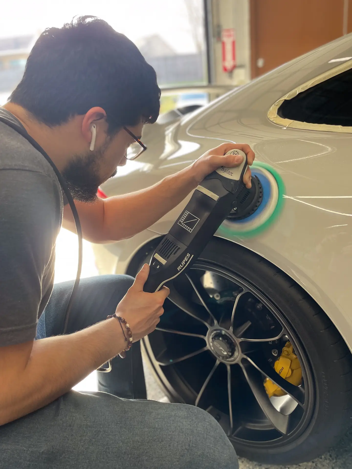 Picture of technician polishing a car's paint by paint correction