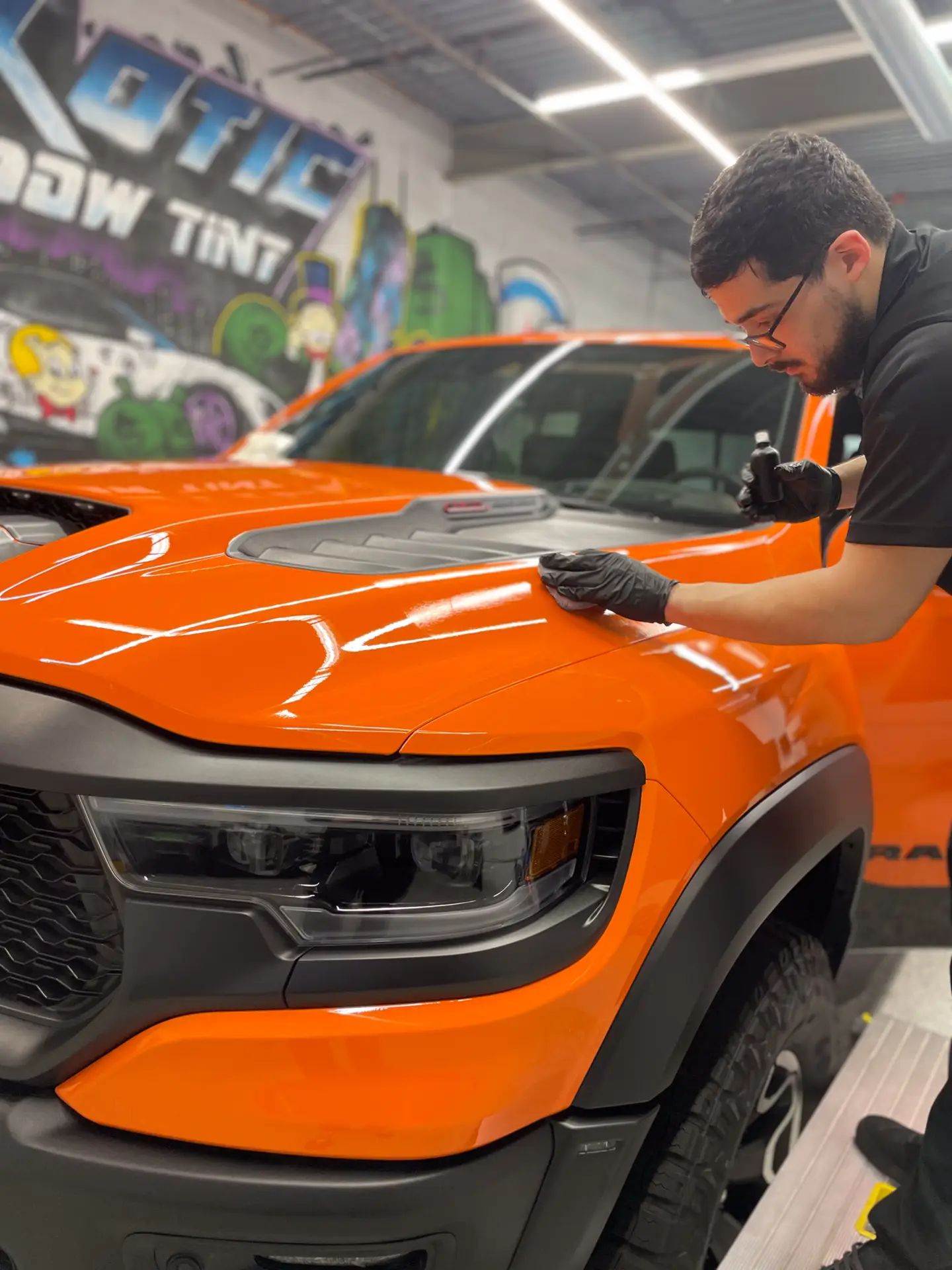 picture of red truck with man installing ceramic coating