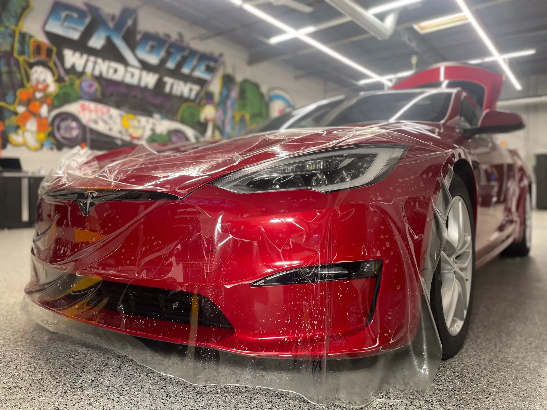 picture of red Tesla with paint protection film being applied