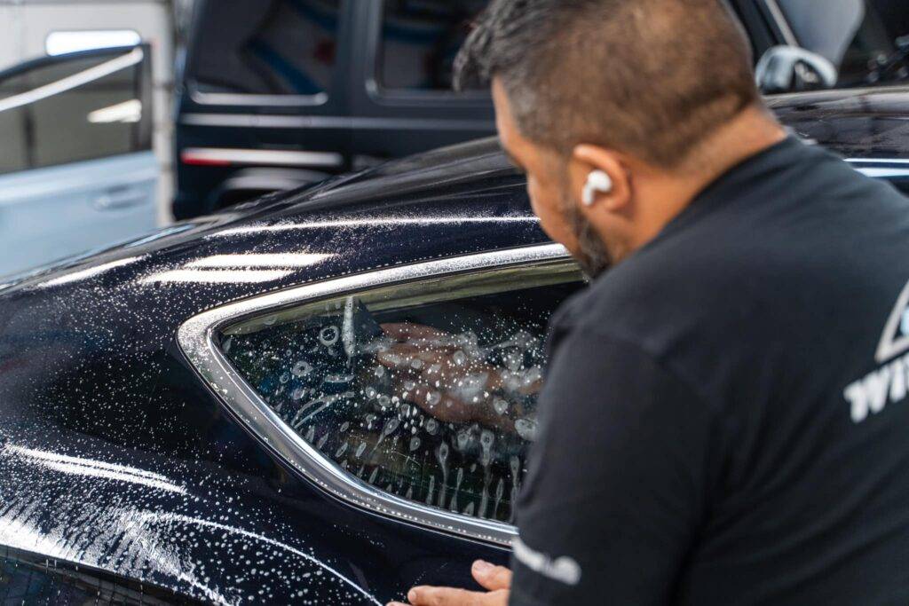 picture of man installing window tint on a car