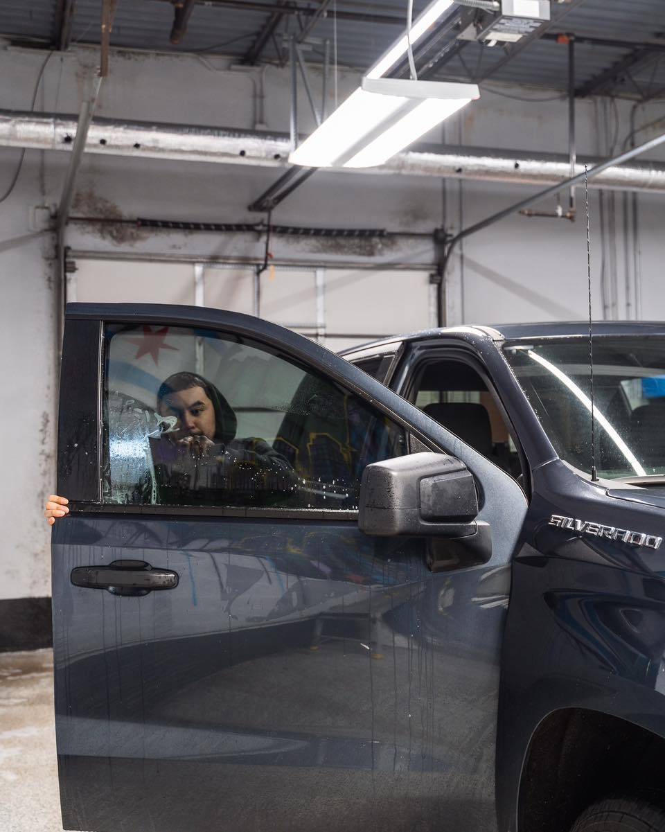 picture of man installing window tint on truck at Exotic Window Tint